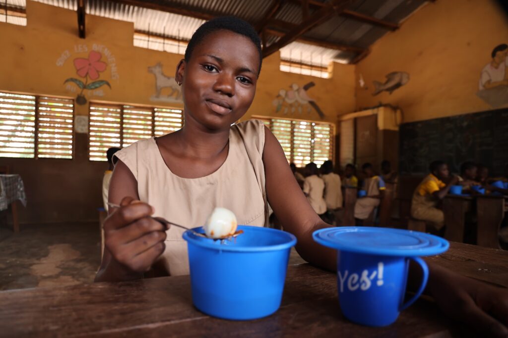 A child in Benin enjoying her school meal.
